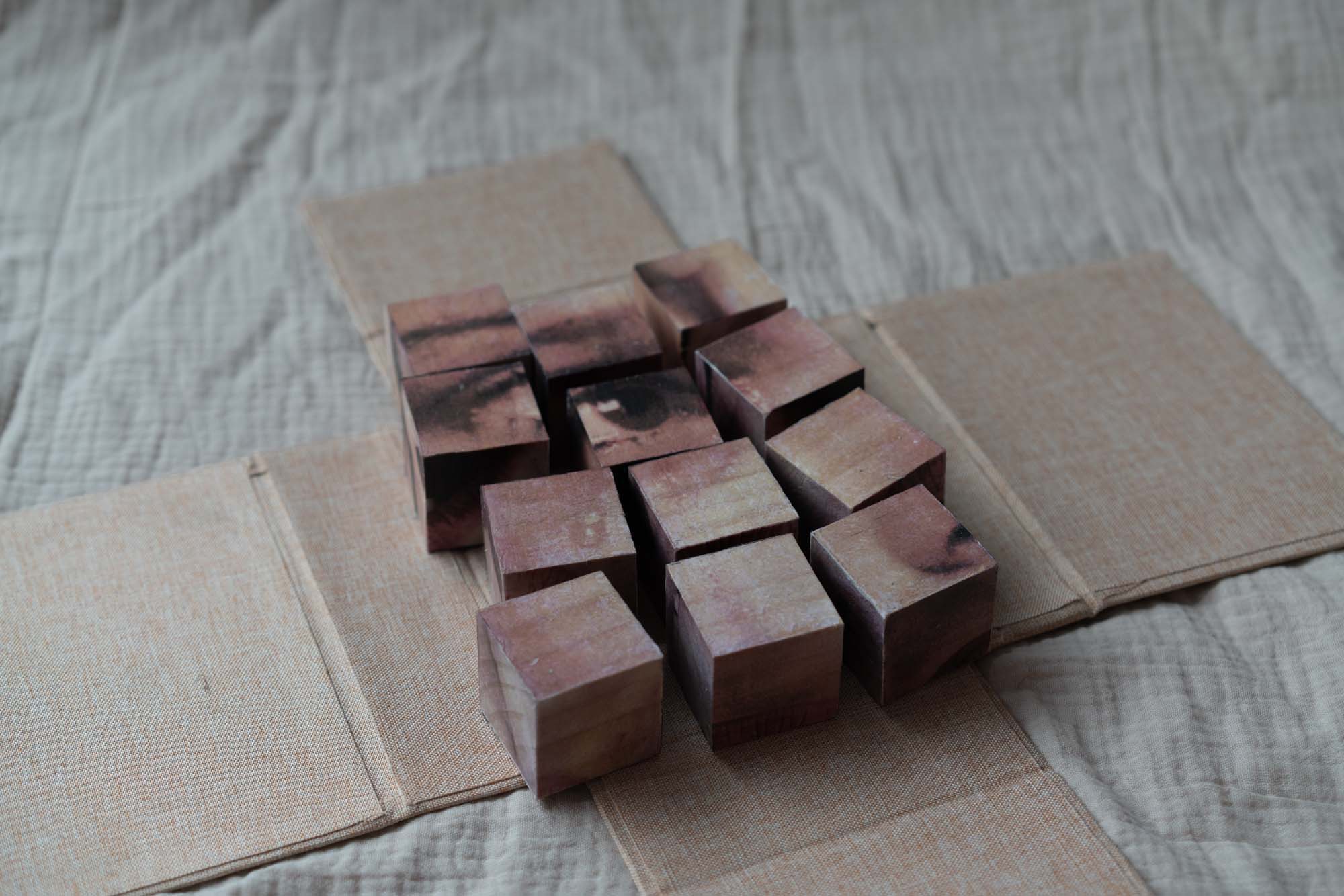 Image-transfered woden cubes slightly scattered over the beige lined box.