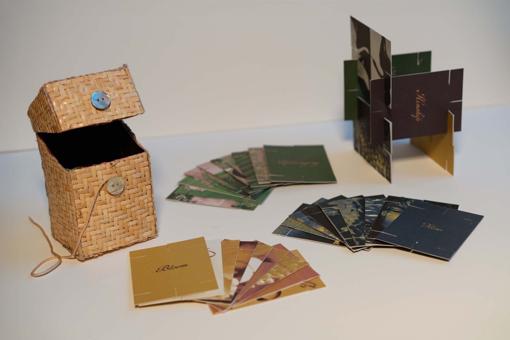 Rattan box standing next to a vertical card formation with cards spread out